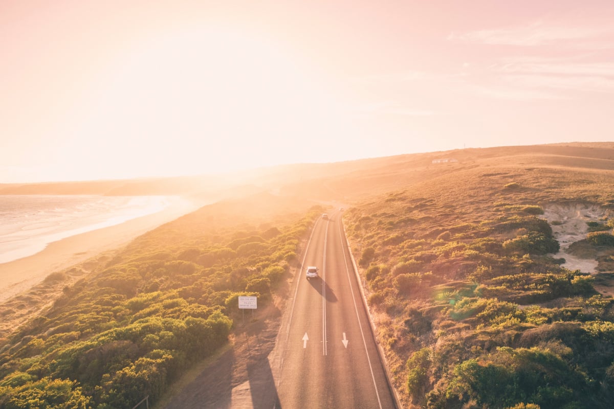 Aerial view of car on a road next to ocean